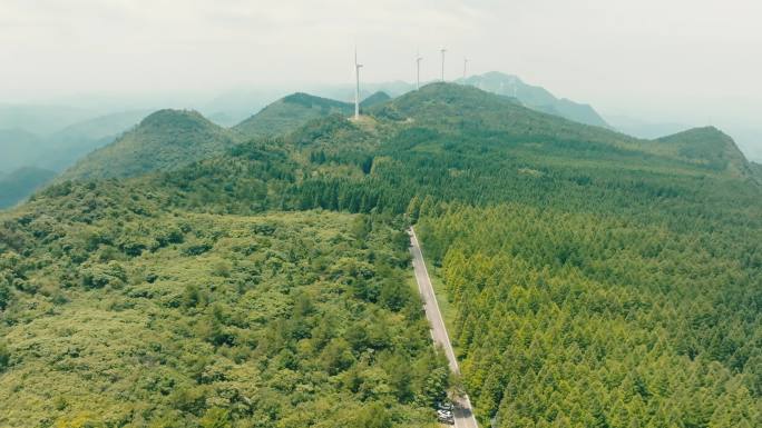 航拍山峰险峰刀背电力风车阳光白云茂密森林