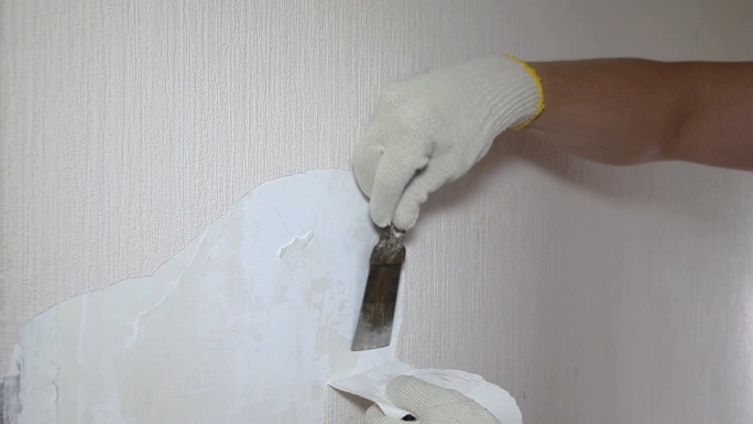男子用工具移除旧墙纸