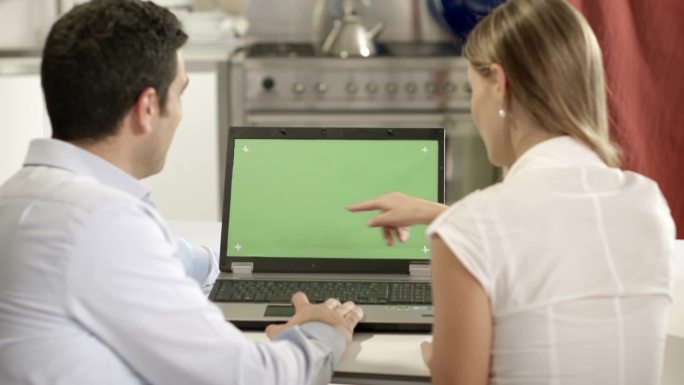 年轻男女使用绿色屏幕的笔记本电脑上网和收发电子邮件