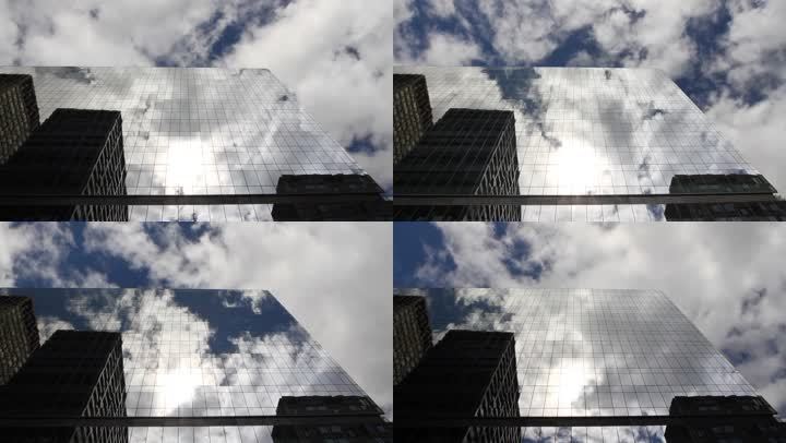 时光流逝，抬头望着一座玻璃覆盖的摩天大楼，映出蓝天、白云和太阳