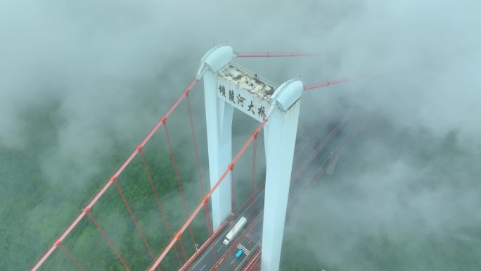 航拍云雾中的大桥上行驶的车辆