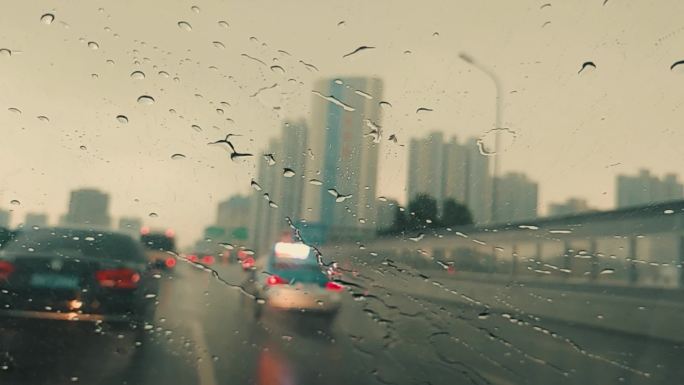 慢动作雨滴打在玻璃上，车在雨中穿梭