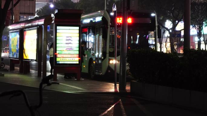 城市街道公交站等车的人登上公交车