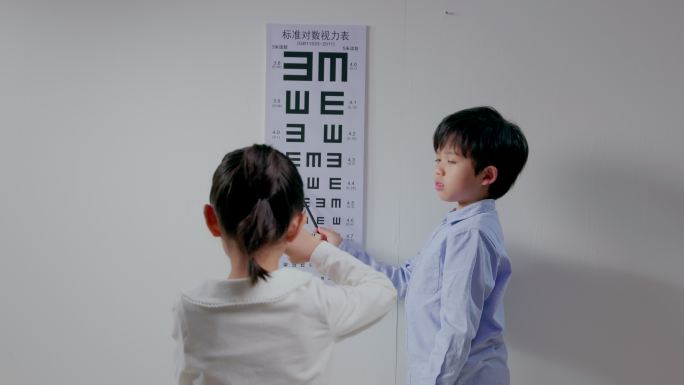 小男孩给小女孩测视力