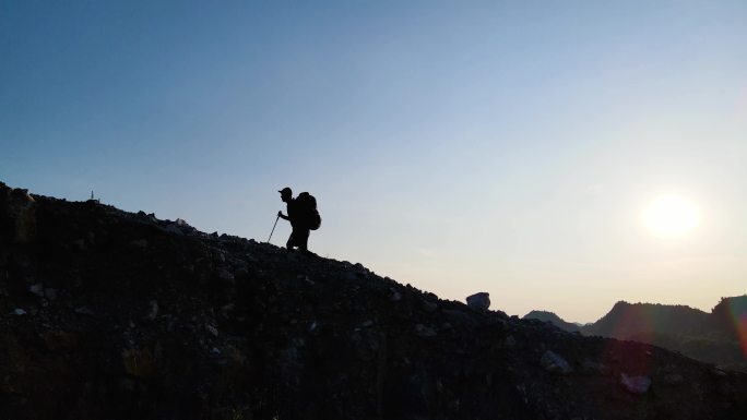 背着登山包艰难登山成功登顶登山人物剪影