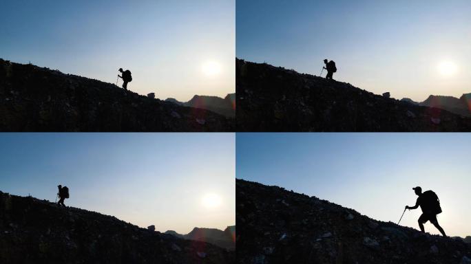 背着登山包艰难登山成功登顶登山人物剪影