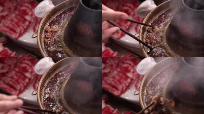 往沸腾的涮肉火锅里夹肉