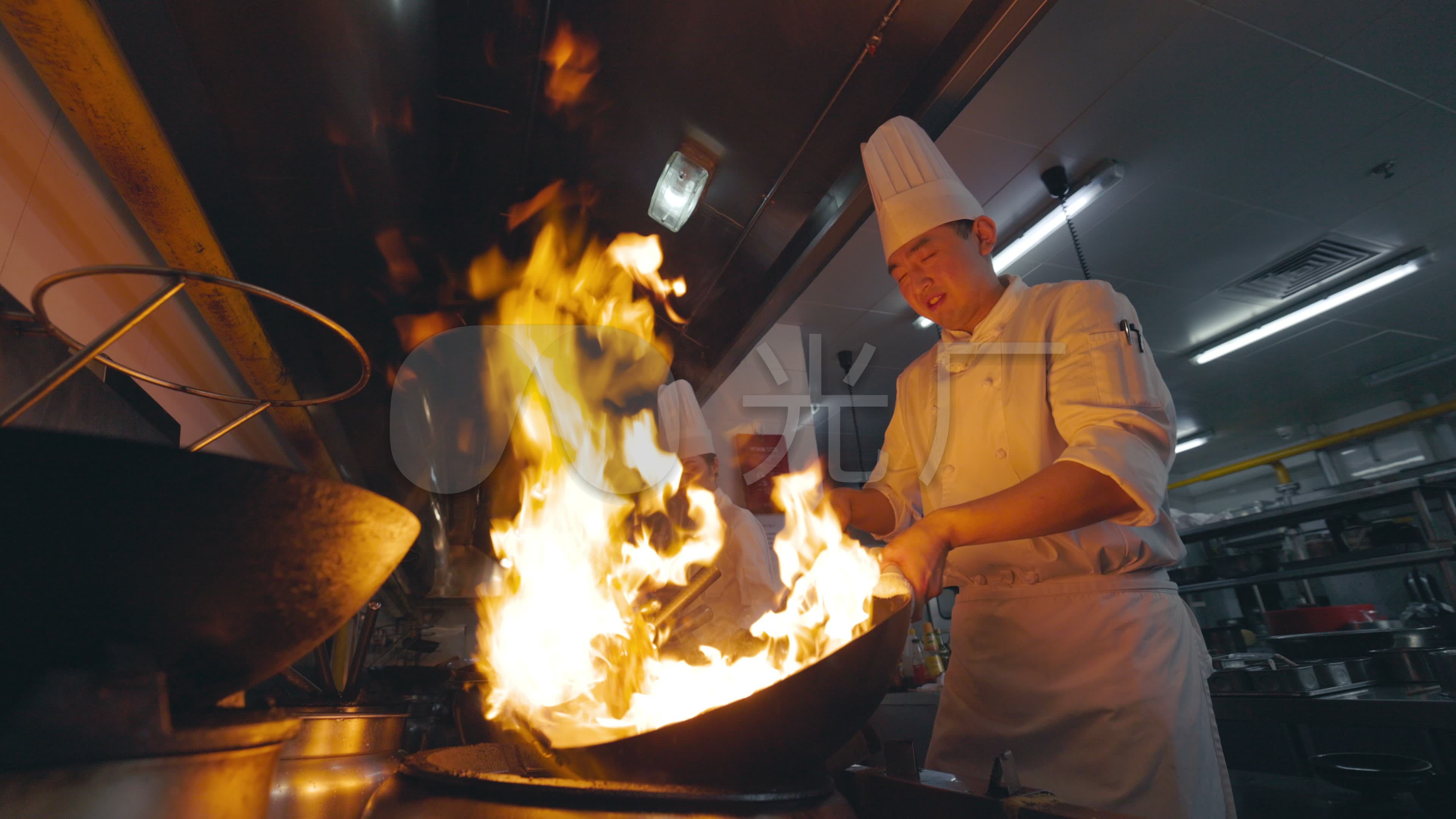 厨师在厨房的煤气炉上用火炒菜图片-商业图片-正版原创图片下载购买-VEER图片库