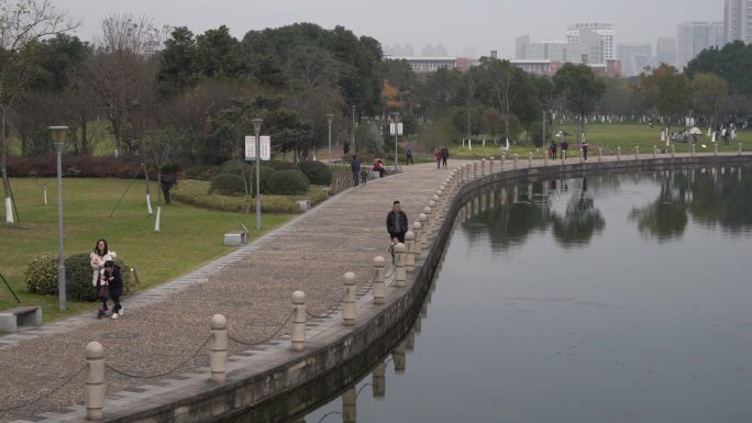 公园湖边游人沿着步道散步