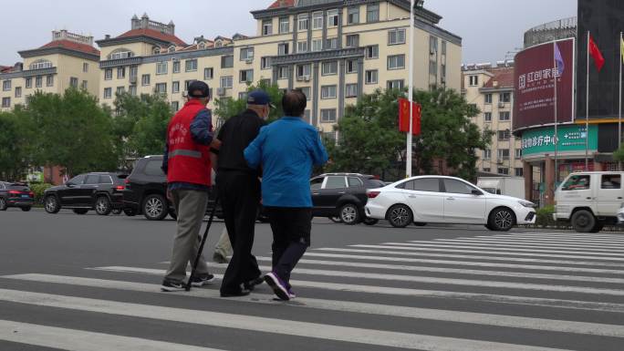 志愿者帮扶老人过马路和谐社会