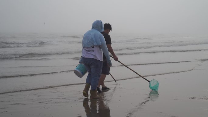渔民赶海挖海鲜捕虾大海边沙滩退潮捕鱼生活
