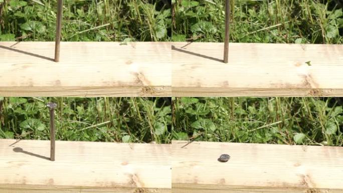 钉子打在绿草上的木板上。