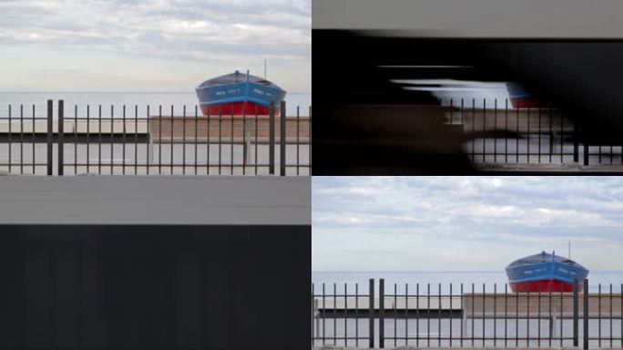 巴塞罗那——2012年5月25日：火车在海滩上的船前经过。