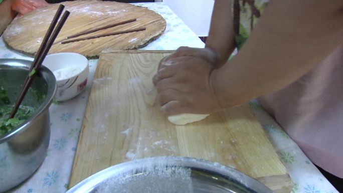 贫困中年妇女在家和面饺子馅包饺子煮饺子