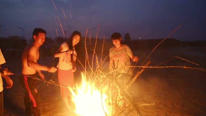 一群年青人在海边点燃篝火