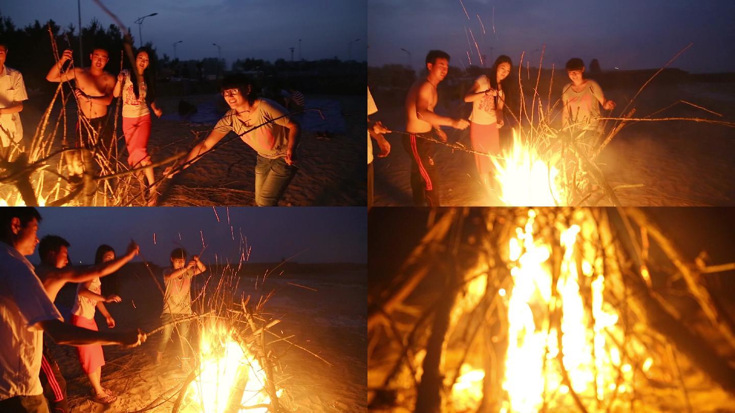 一群年青人在海边点燃篝火