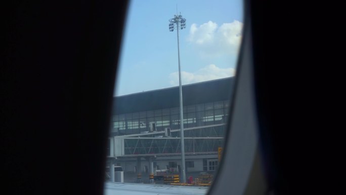 飞机舷窗看机场航站楼和蓝天白云