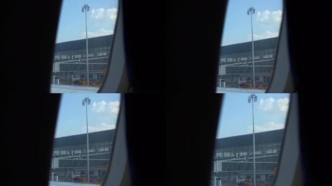飞机舷窗看机场航站楼和蓝天白云