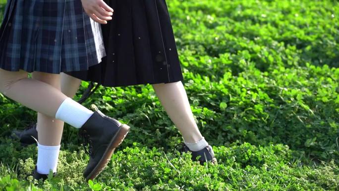 两个女孩行走奔跑在绿草地上