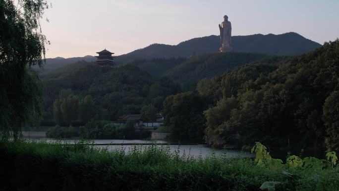 柳树湖面寺庙山林大佛前飞