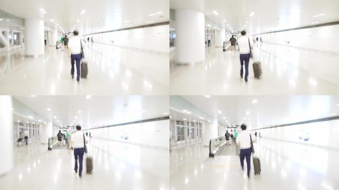 拖着行李箱行走在机场大厅内的男性乘客
