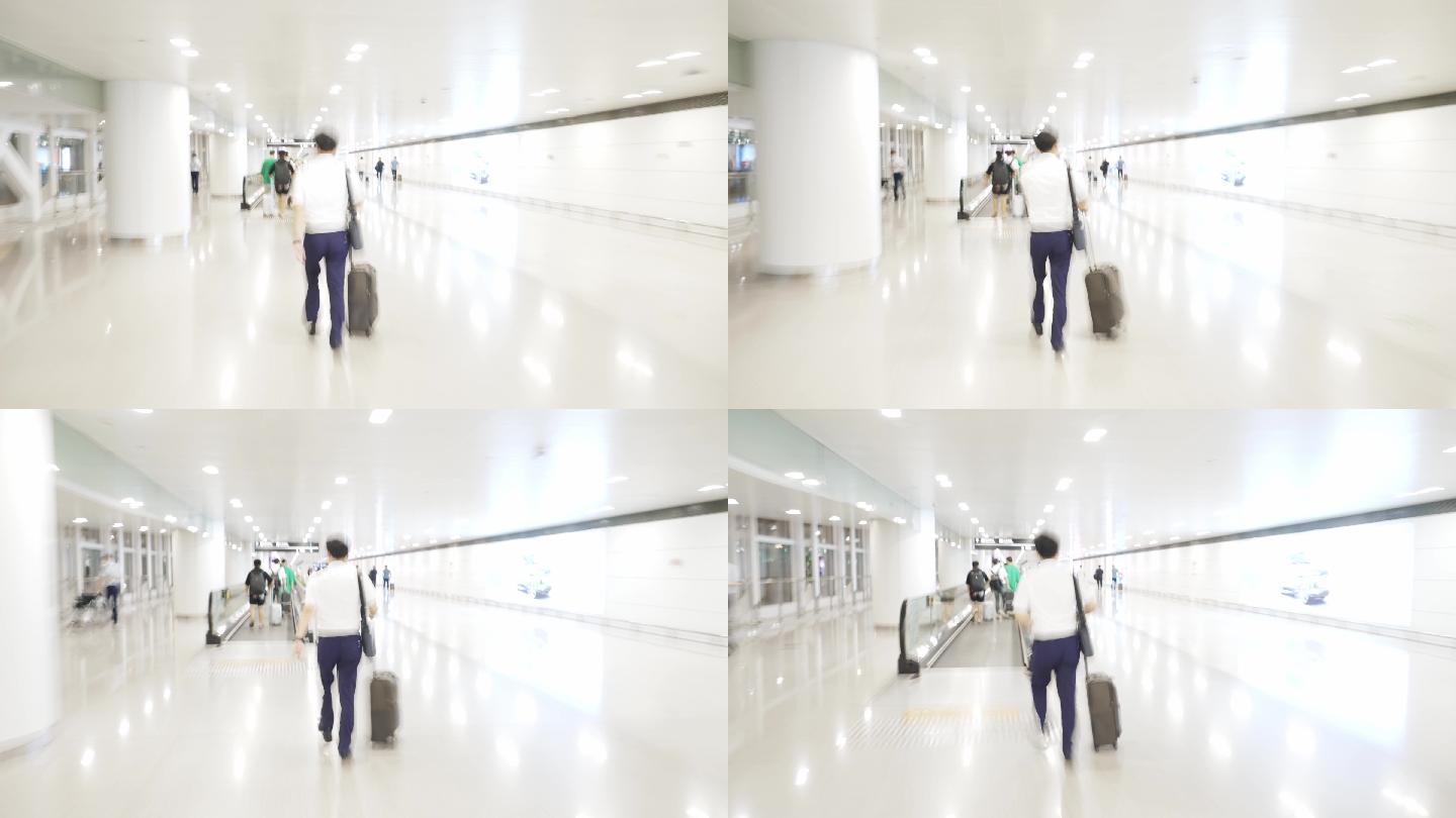 拖着行李箱行走在机场大厅内的男性乘客
