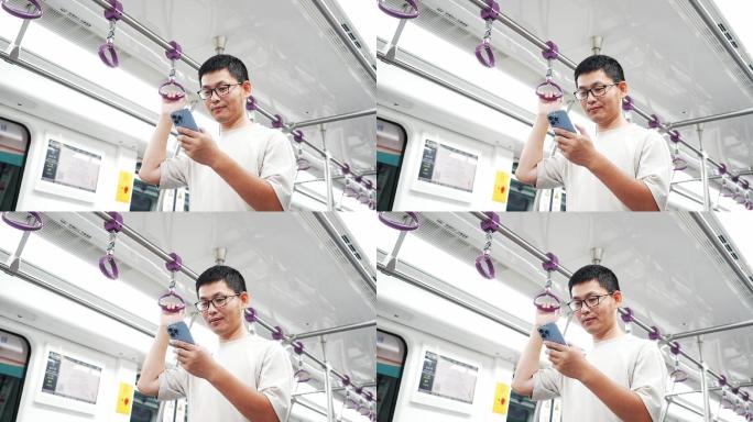男子在地铁上用手机玩手机