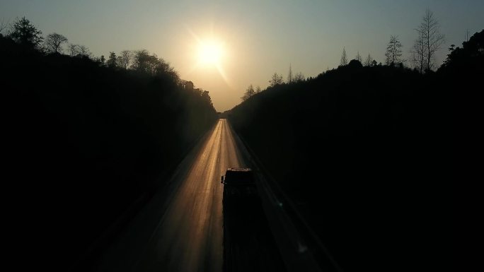 夕阳下公路上行驶的汽车剪影