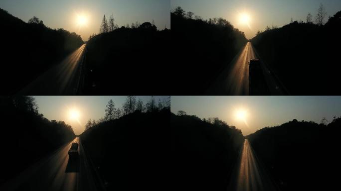 夕阳下公路上行驶的汽车剪影
