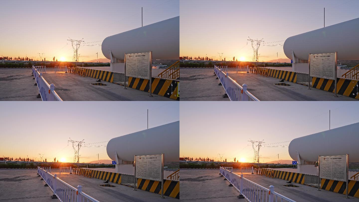 夕阳下高压电线塔附近巨大的储氢罐航拍