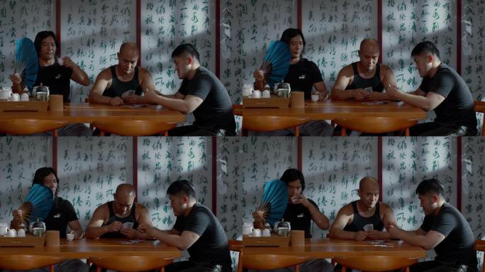 三个男人在打牌喝茶