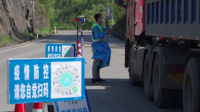 疫情道路管控人员举牌让货车扫码