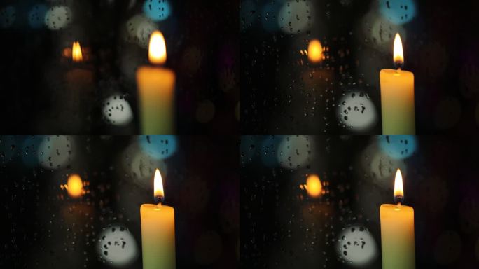 落满雨水的玻璃窗旁的烛光