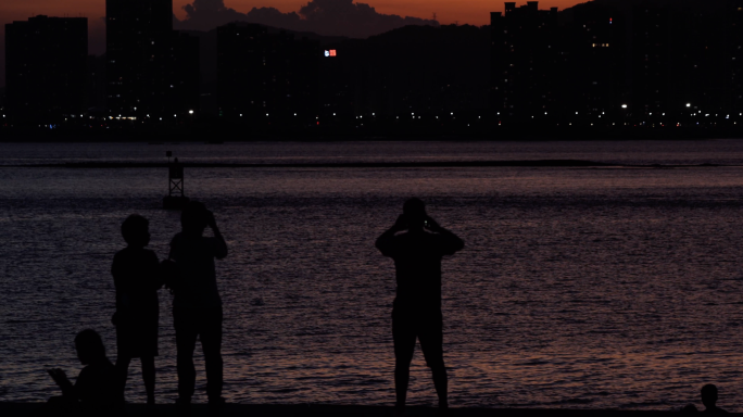 4k 夕阳西下 海边的身影和远处的城