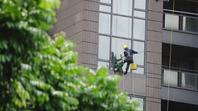 一个工人高空作业清洗建筑外墙