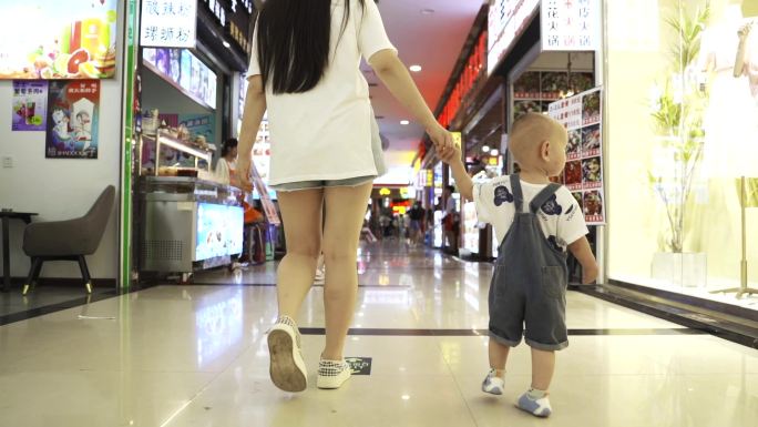 母子年轻妈妈带着小男孩逛商场步行街母爱