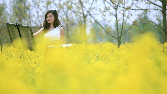 油菜花海里的女孩户外写生的女孩