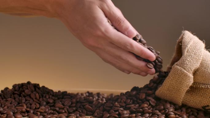 双手麻袋装咖啡豆手捧咖啡豆掉落慢动作广告