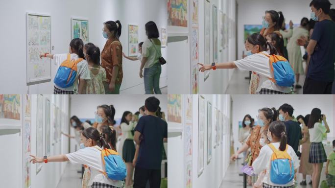 一群家长孩子欣赏鉴赏少年美术画作品