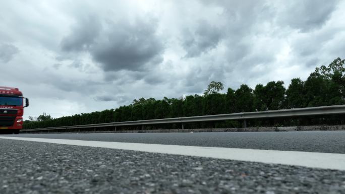 低角度拍摄乌云下高速公路过往的汽车