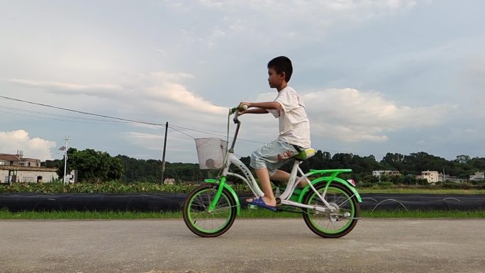 乡村傍晚小孩骑自行车乡村孩子顽皮乡间骑车