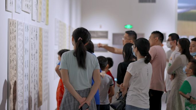 老师带着学生家长参观书法艺术展