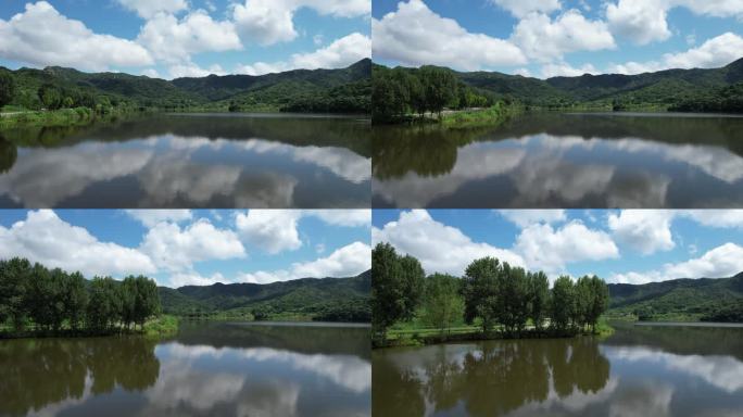 航拍湖水倒映中的山川绿树与蓝天白云