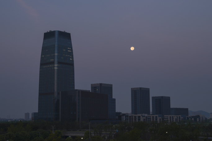 城市CBD月亮落下阳光照耀延时