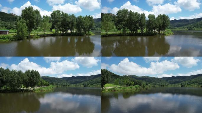 航拍湖水倒映中的山川绿树与蓝天白云
