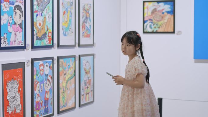 参观少年美术画展的小女孩拍照学习