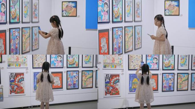 参观少年美术画展的小女孩拍照学习