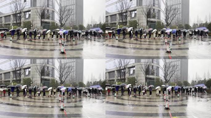 下雨天市民排队在城市广场上做核酸