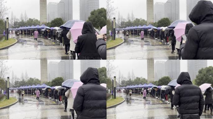下雨天市民排队在城市广场上做核酸