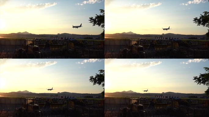 日落时一架即将降落的飞机在机场跑道上空